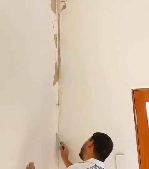 Interior painter preparing peeling walls for repainting in Adelaide