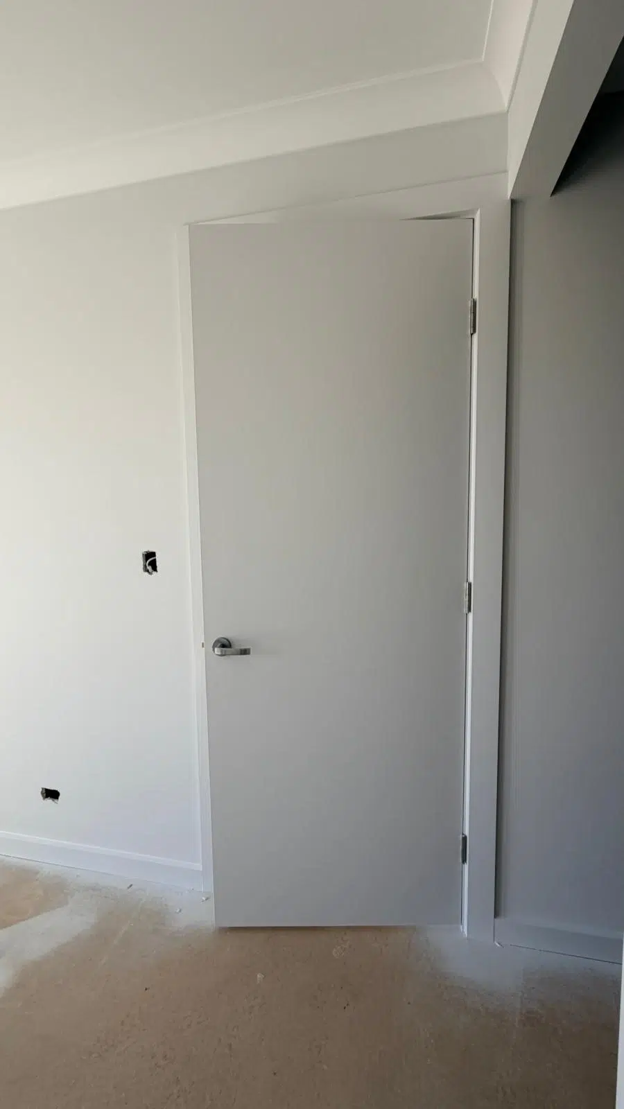 A professional painter applies primer to an interior wall before the final paint coats. Proper surface preparation can help improve adhesion, coverage and the overall appearance of the finished paintwork.